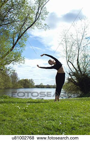 Young female dancer practicing near lake View Large Photo Image Stock Photo - Young female dancer practicing near lake. Fotosearch
