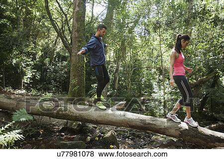 Young joggers balancing on tree trunk View Large Photo Image Stock Photo - Young joggers balancing on tree trunk. Fotosearch