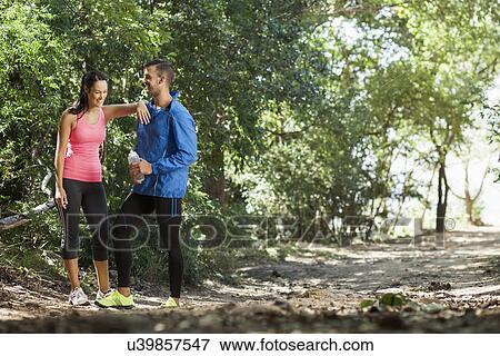 Young joggers taking break in forest View Large Photo Image Stock Photo - Young joggers taking break in forest. Fotosearch