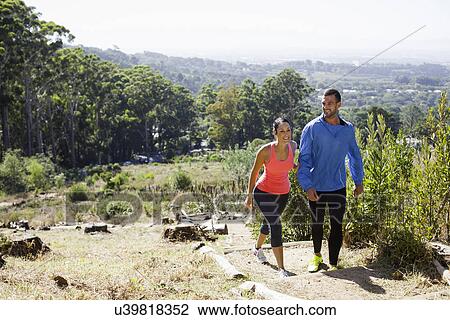 Stock Image - Young joggers walking in forest. Fotosearch