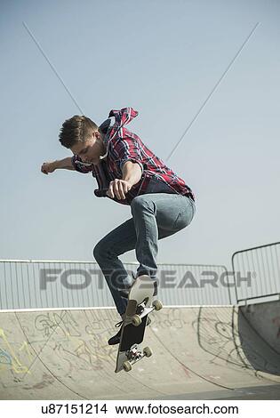 Young man doing skateboarding trick View Large Photo Image Picture - Young man doing skateboarding trick. Fotosearch