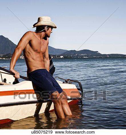Young man leaning against power boat, Verbania, Italy View Large Photo Image Stock Photo - Young man leaning against power boat, Verbania, Italy. Fotosearch