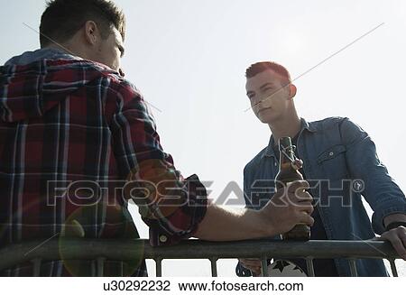 Young men in skatepark, drinking bottle of beer View Large Photo Image Stock Image - Young men in skatepark, drinking bottle of beer. Fotosearch