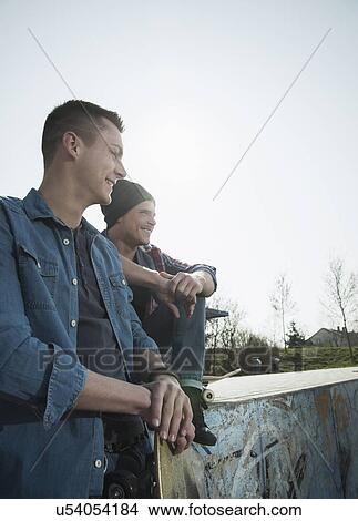Young men sitting together at skatepark View Large Photo Image Picture - Young men sitting together at skatepark. Fotosearch