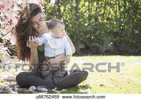 Young mother and baby son relaxing in garden View Large Photo Image Stock Photo - Young mother and baby son relaxing in garden. Fotosearch