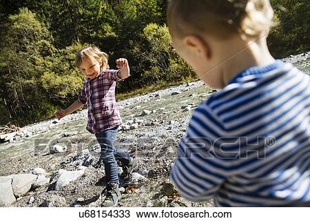 Young sister and brother playing on riverside View Large Photo Image Stock Image - Young sister and brother playing on riverside. Fotosearch