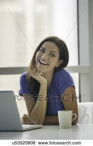 Young woman at table with laptop and coffee View Large Photo Image Stock Photo - Young woman at table with laptop and coffee. Fotosearch