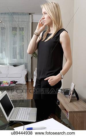 Young woman chatting on smartphone in dining room View Large Photo Image Stock Photo - Young woman chatting on smartphone in dining room. Fotosearch
