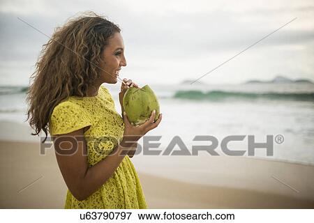 Young woman drinking coconut milk on Ipanema Beach, Rio de Janeiro, Brazil View Large Photo Image Stock Photo - Young woman drinking coconut milk on Ipanema Beach, Rio de Janeiro, Brazil. Fotosearch