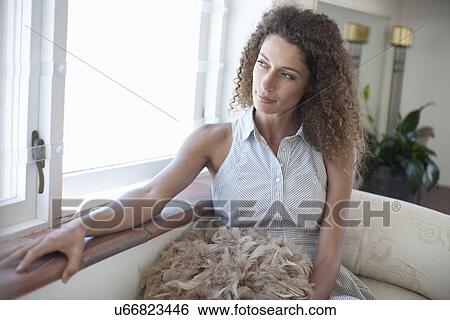Young woman gazing out of apartment window View Large Photo Image Stock Photograph - Young woman gazing out of apartment window. Fotosearch