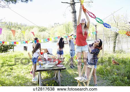 Stock Photo - Young woman hanging up bunting. Fotosearch