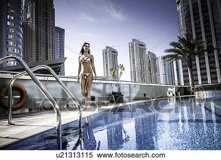 Young woman in bikini at rooftop swimming pool, Dubai, United Arab Emirates View Large Photo Image Stock Photography - Young woman in bikini at rooftop swimming pool, Dubai, United Arab Emirates. Fotosearch