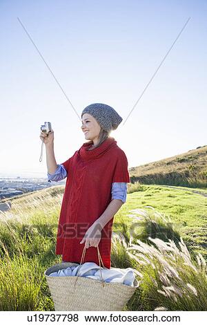 Young woman photographing view from hill View Large Photo Image Stock Photo - Young woman photographing view from hill. Fotosearch