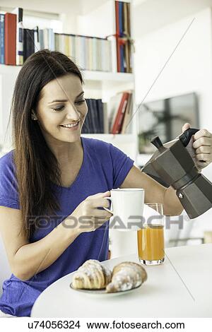 Young woman pouring coffee for breakfast View Large Photo Image Picture - Young woman pouring coffee for breakfast. Fotosearch
