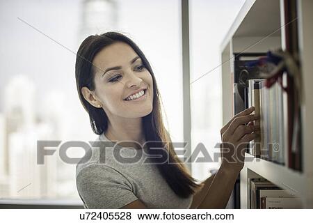 Young woman searching bookshelves View Large Photo Image Stock Photo - Young woman searching bookshelves. Fotosearch