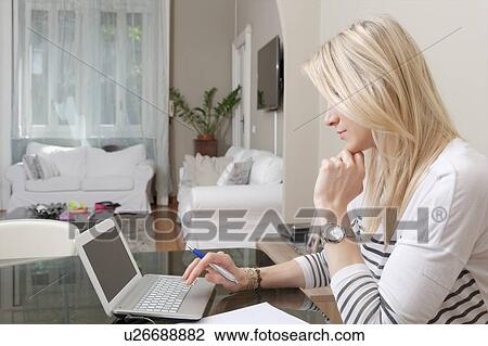 Young woman typing on laptop at home desk View Large Photo Image Stock Image - Young woman typing on laptop at home desk. Fotosearch