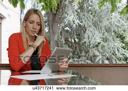 Young woman using digital tablet on balcony View Large Photo Image Stock Image - Young woman using digital tablet on balcony. Fotosearch