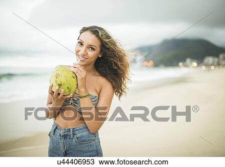 Young woman with coconut milk on Ipanema Beach, Rio de Janeiro, Brazil View Large Photo Image Stock Image - Young woman with coconut milk on Ipanema Beach, Rio de Janeiro, Brazil. Fotosearch