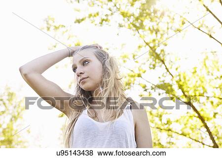Young woman with hand in hair View Large Photo Image Stock Photo - Young woman with hand in hair. Fotosearch