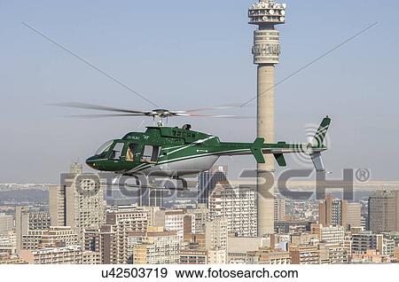 Bell 407 helicopter flying over a city View Large Photo Image Stock Photo - Bell 407 helicopter flying over a city. Fotosearch
