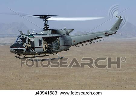 Stock Image - Bell Huey II in flight over the Registan Desert. Fotosearch