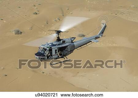 Stock Image - Bell Huey II in flight over the Registan Desert. Fotosearch
