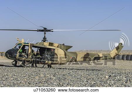 Stock Image - Bell Huey II refueling at a forward operating base. Fotosearch