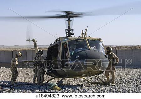 Stock Image - Bell Huey II refuelling at a forward operating base. Fotosearch