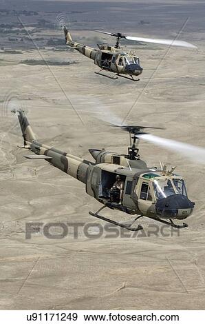 Stock Photo - Bell Huey IIs in flight near Kabul, Afghanistan.. Fotosearch