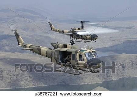 Stock Image - Bell Huey IIs in flight over Naghlu dam, Afghanistan.. Fotosearch