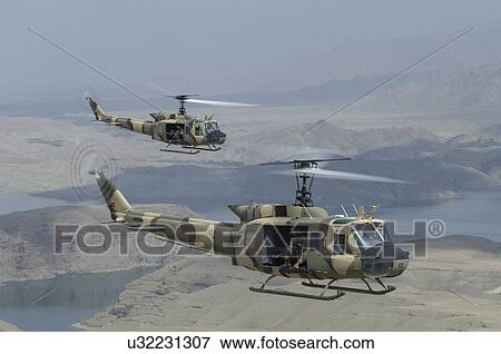 Stock Photo - Bell Huey IIs in flight over Naghlu dam, Afghanistan. Fotosearch