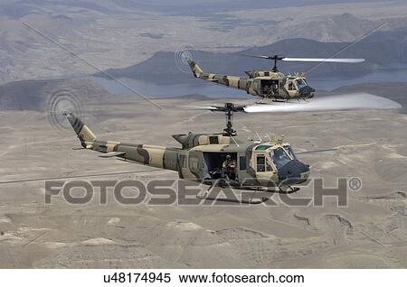 Stock Photography - Bell Huey IIs in flight over Naghlu dam, Afghanistan.. Fotosearch