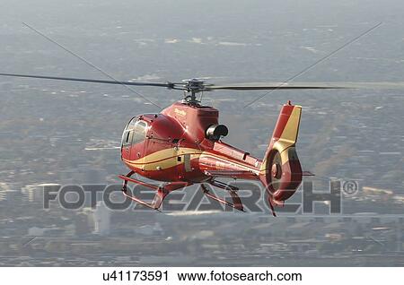 Stock Image - EC130B4 in flight over Melbourne. Fotosearch