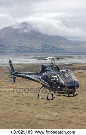 Stock Photo - Eurocopter (Aerospatiale) AS350BA Methven over the Rakaia River, South Island, New Zealand. Fotosearch