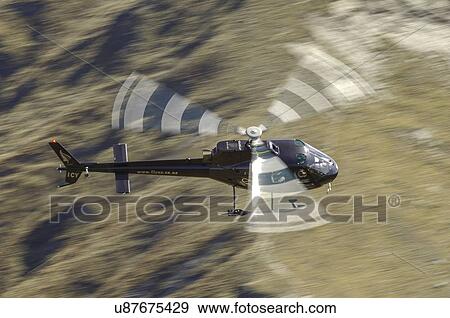 Stock Photo - Eurocopter AS350 in flight near Queenstown, New Zealand. Fotosearch