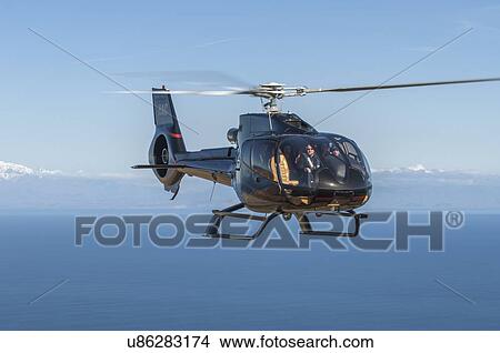 Picture - Eurocopter EC130B4 in flight off the west coast of Wellington, New Zealand.. Fotosearch