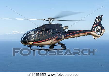 Stock Image - Eurocopter EC130B4 in flight off the west coast of Wellington. Fotosearch