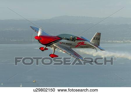 Stock Image - Extra Aircraft Extra 300 in flight over the Hauraki Gulf. Fotosearch