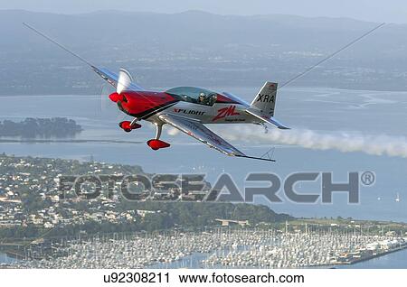 Stock Image - Extra Aircraft Extra 300 in flight over Auckland . Fotosearch