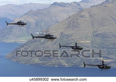 Stock Image - Helicopter formation over Lake Wakatipu near Queenstown. Fotosearch