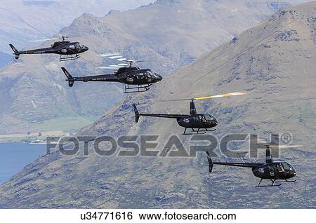 Stock Photograph - Helicopter formation over Lake Wakatipu near Queenstown, New Zealand of two Robinson R44s and two Eurocopter AS350s. Fotosearch