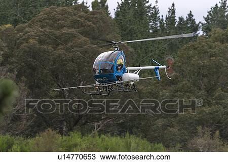 Stock Image - Hughes 269C flight conducting aerial spraying. Fotosearch