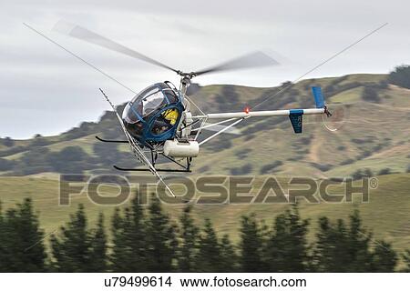 Picture - Hughes 269C in flight conducting aerial spraying. Fotosearch