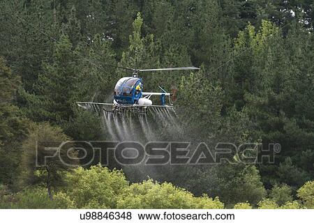 Stock Photo - Hughes 269C in flight conducting aerial spraying. Fotosearch