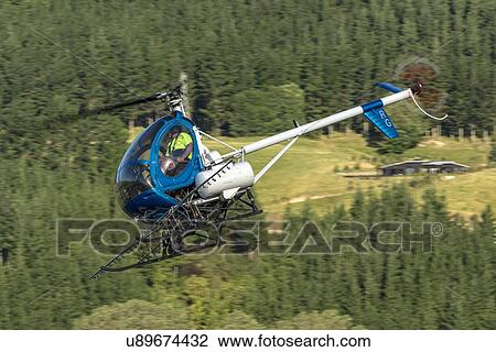 Stock Image - Hughes 269C in flight. Fotosearch