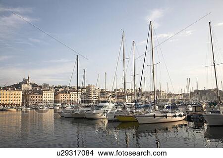 Picture - Boats anchored with city in the distance. Fotosearch