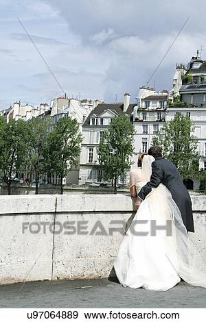 Bride and groom on bridge looking at buildings View Large Photo Image Stock Photo - Bride and groom on bridge looking at buildings. Fotosearch