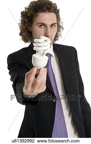 Business man holding energy efficient light bulb View Large Photo Image Stock Image - Business man holding energy efficient light bulb. Fotosearch