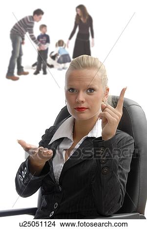 Picture - Business woman sitting in office chair with family playing in the background. Fotosearch