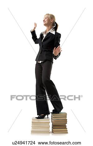 Business woman standing on book stacks View Large Photo Image Picture - Business woman standing on book stacks. Fotosearch